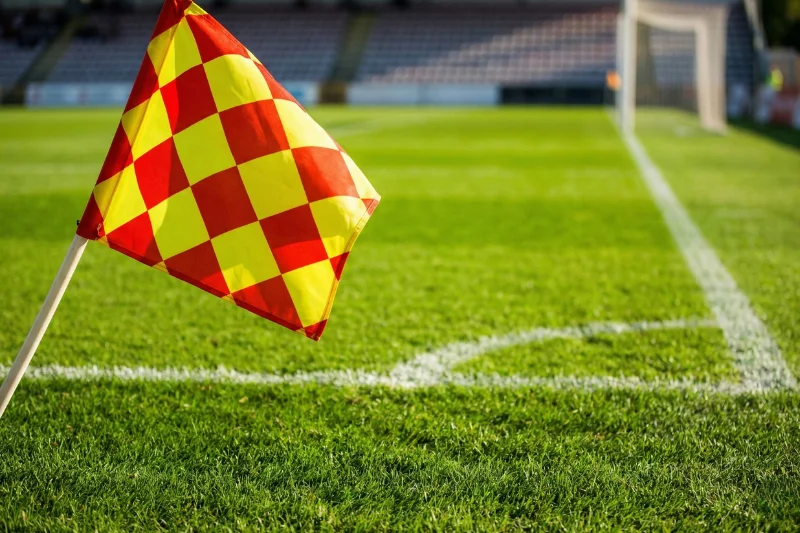 Bandeirola de canto a ondular num campo de futebol com relvado verde